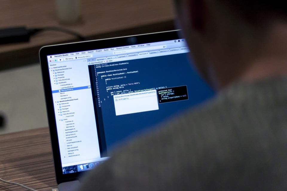 A laptop screen showing code in an editor, seen over someone's shoulder.